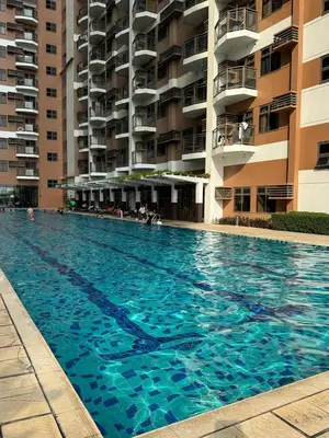a large swimming pool in front of a building at Cozy, aesthetic Pet friendly 1br Condo with balcony in Pasay with Manila Bay View Near MOA & Okada WFH ready Free Pool Acces Gym and Sauna in Manila