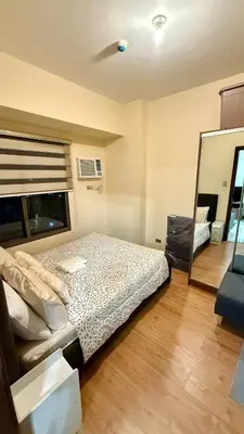 a bedroom with a bed and a mirror at Cozy, aesthetic Pet friendly 1br Condo with balcony in Pasay with Manila Bay View Near MOA & Okada WFH ready Free Pool Acces Gym and Sauna in Manila