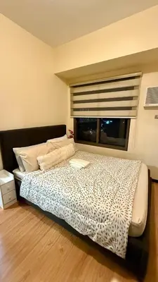 a bedroom with a large bed with a window at Cozy, aesthetic Pet friendly 1br Condo with balcony in Pasay with Manila Bay View Near MOA & Okada WFH ready Free Pool Acces Gym and Sauna in Manila
