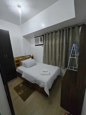 a bedroom with a bed and a ladder in it at SMDC Shine Residence in Manila
