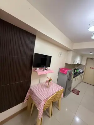 a small kitchen with a table with a pink table cloth at R&K Staycation in Manila