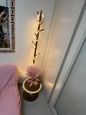 a room with a bed and a shelf with a plant at R&K Staycation in Manila