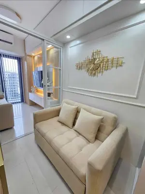a living room with a couch and a painting on the wall at Stylish and Glamours Haven in Manila
