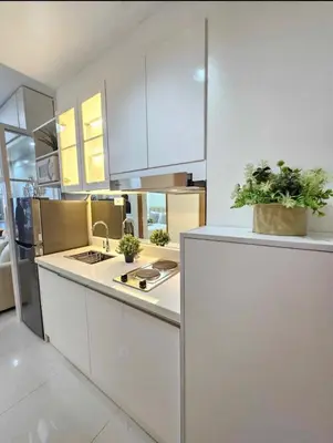 a kitchen with white cabinets and potted plants on the counter at Stylish and Glamours Haven in Manila