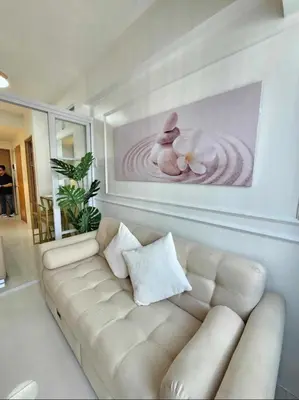 a living room with a white couch and a painting at Stylish and Glamours Haven in Manila