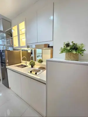 a kitchen with white cabinets and plants on a counter at Stylish and Glamours Haven in Manila