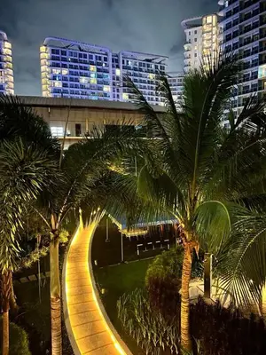 a street with palm trees in a city at night at Hiraya Pod Staycation Netflix Balcony Beach Escape in Manila