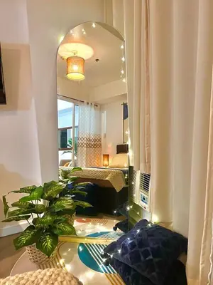 a living room with a large mirror and a bedroom at Hiraya Pod Staycation Netflix Balcony Beach Escape in Manila