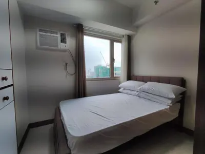 a small bedroom with a bed and a window at Manila Bay Coast Residences 1BR Flat in Manila