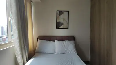 a bed in a room with a picture on the wall at Manila Bay Coast Residences 1BR Flat in Manila