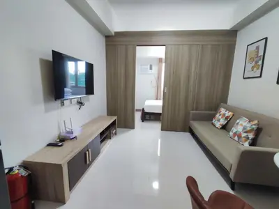 a living room with a couch and a flat screen tv at Manila Bay Coast Residences 1BR Flat in Manila