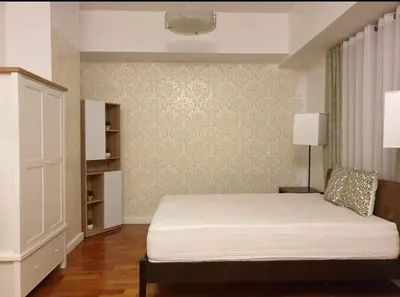 a bedroom with a bed and a dresser at Spacious Studio no balcony in Mosaic Tower with WiFi and Smart TV in Manila