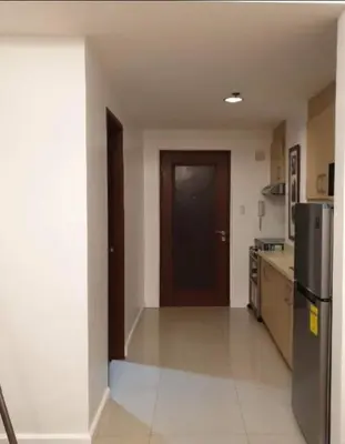 a kitchen with a black door and a refrigerator at Spacious Studio no balcony in Mosaic Tower with WiFi and Smart TV in Manila