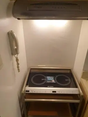 a stove in the corner of a refrigerator with a phone at Spacious Studio no balcony in Mosaic Tower with WiFi and Smart TV in Manila