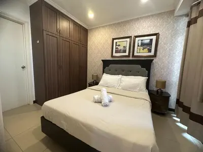 a teddy bear sitting on a bed in a bedroom at Sunset View 1 BR with balcony FREE Pool&Gym Access in Manila