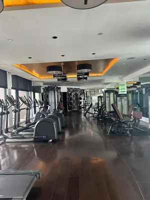 a gym with a lot of treadmills and chairs at Sunset View 1 BR with balcony FREE Pool&Gym Access in Manila