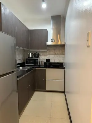 a kitchen with a refrigerator and a stove top oven at Sunset View 1 BR with balcony FREE Pool&Gym Access in Manila