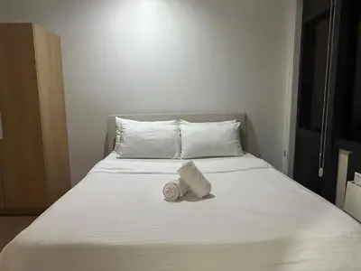 a bed with a white towel on top of it at Minimalist 1 Bedroom Sunset View in Gramercy in Manila
