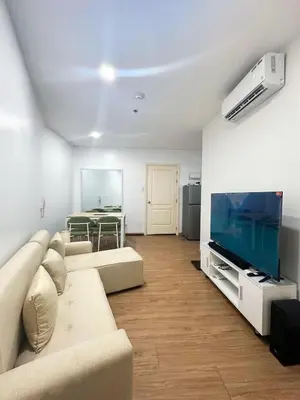 a living room with a couch and a flat screen tv at Minimalist 1 Bedroom Sunset View in Gramercy in Manila