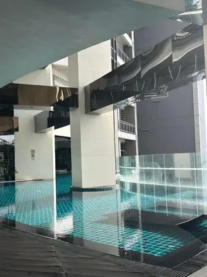 a swimming pool in a building with a water fountain at Minimalist 1 Bedroom Sunset View in Gramercy in Manila