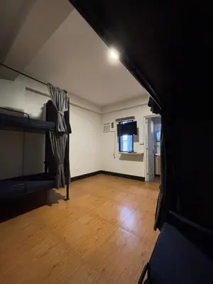 an empty room with a bunk bed and wooden floors at The Budget Inn in Manila