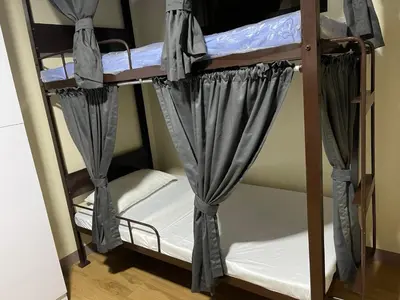 a couple of bunk beds with curtains on them at The Budget Inn in Manila