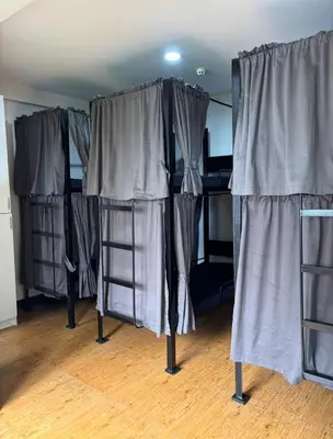 a group of bunk beds in a room with curtains at The Budget Inn in Manila