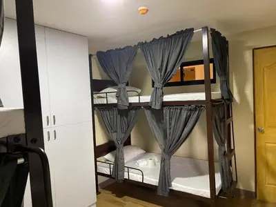 a room with bunk beds with curtains on them at The Budget Inn in Manila