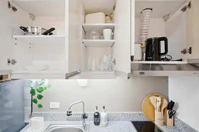 a kitchen with white cabinets and a sink at CABIN STUDIO in KL TOWER, Greenbelt, Makati! Max Capacity 6 pax! in Manila