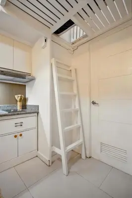 a kitchen with a ladder in the corner of a room at CABIN STUDIO in KL TOWER, Greenbelt, Makati! Max Capacity 6 pax! in Manila