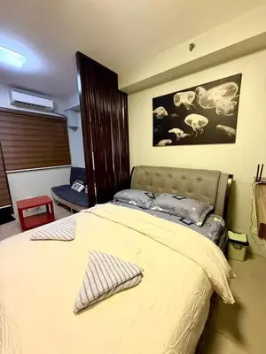 a bedroom with a bed with a pillow on it at Shore 2 tower 2 near moa in Manila