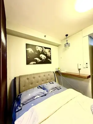 a bedroom with a bed and a picture on the wall at Shore 2 tower 2 near moa in Manila