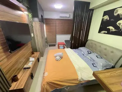 a bedroom with a large bed and a television at Shore 2 tower 2 near moa in Manila