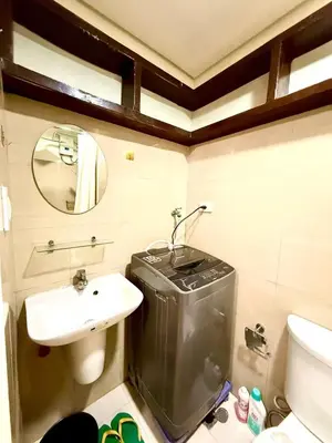 a bathroom with a sink and a toilet and a mirror at Shore 2 tower 2 near moa in Manila
