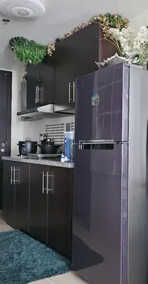 a kitchen with black cabinets and a stainless steel refrigerator at Aiko's Haven at Kasara in Manila