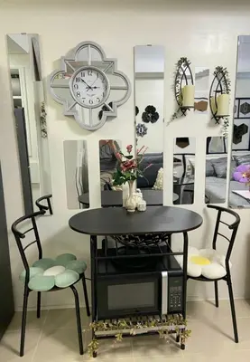 a dining room with a table and a clock and mirrors at Aiko's Haven at Kasara in Manila