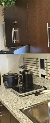 a kitchen counter with a stove with a pot on it at Aiko's Haven at Kasara in Manila
