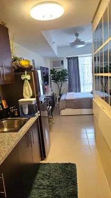 a kitchen with a refrigerator and a room with a bed at Aiko's Haven at Kasara in Manila