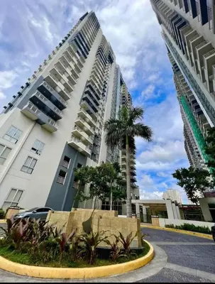 a tall white building with a palm tree in front of it at Aiko's Haven at Kasara in Manila