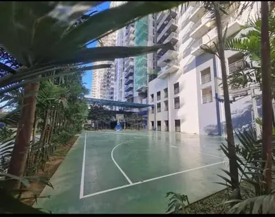 a tennis court in the middle of a building with palm trees at Aiko's Haven at Kasara in Manila
