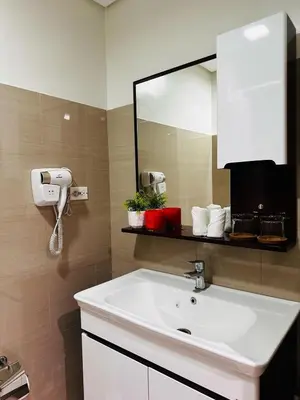 a bathroom with a white sink and a mirror at Shore2 Residence Pasay by N&R Valmont in Manila