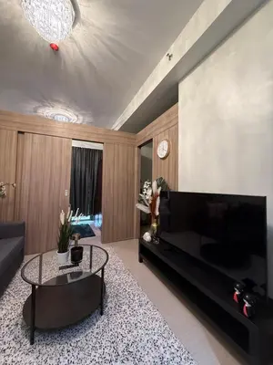 a living room with a large television and a table at Shore2 Residence Pasay by N&R Valmont in Manila