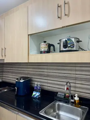 a kitchen with a sink and a toaster on a shelf at Cozy Nook in the City of Mandaluyong in Manila