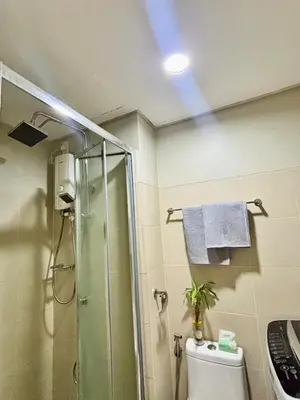 a bathroom with a glass shower and a toilet at Stylish City Escape in Manila