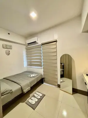 a small bedroom with a bed and a desk at Stylish City Escape in Manila