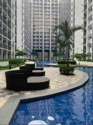 a pool with a couch and chairs in front of tall buildings at Chic City Escape by the Bay in Manila