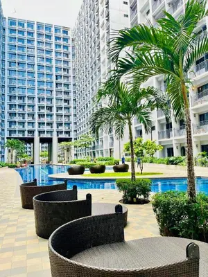 a courtyard with chairs and palm trees in a building at Chic City Escape by the Bay in Manila