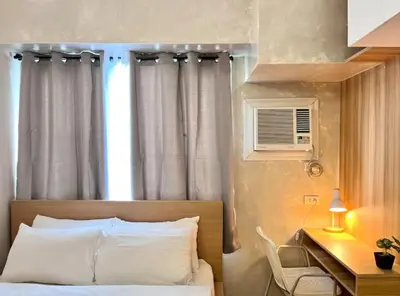 a bedroom with a bed and a desk and a window at 1BR Condotel Ridgewood Towers Near BGC Airport #RW17 in Manila