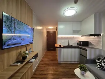 a kitchen with a tv on a wall in a room at 1BR Condotel Ridgewood Towers Near BGC Airport #RW17 in Manila
