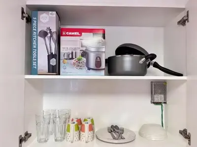 a kitchen shelf with cookbooks and other items on it at 1BR Condotel Ridgewood Towers Near BGC Airport #RW17 in Manila